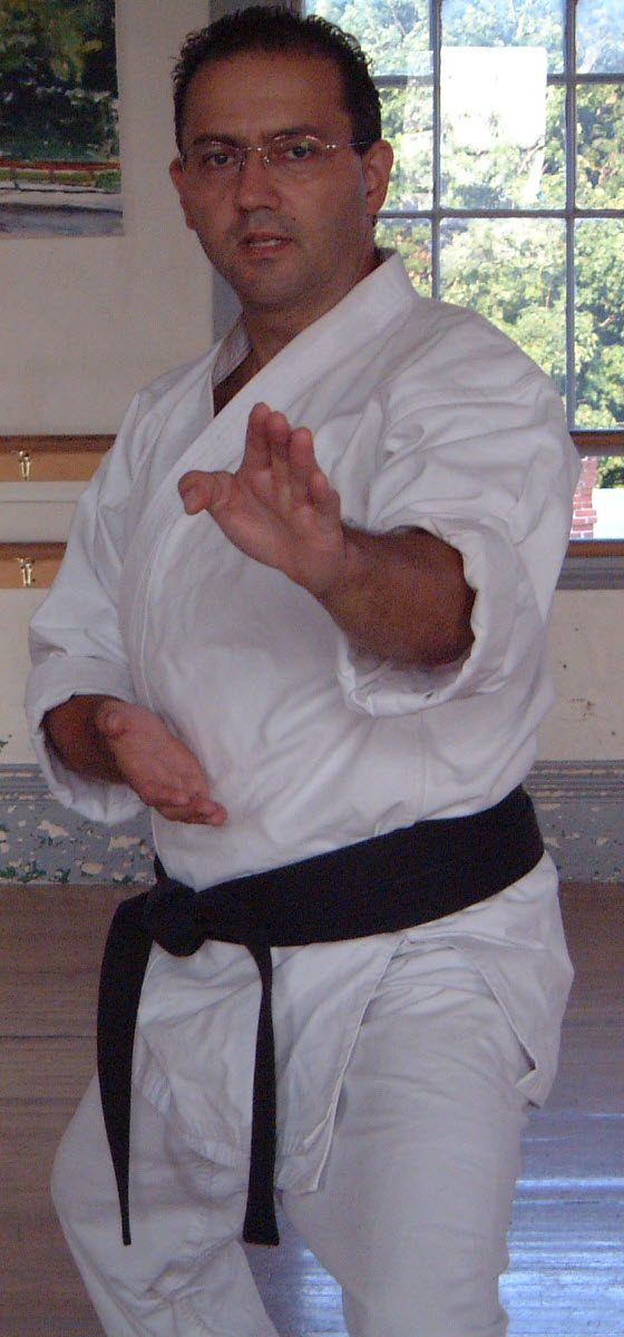 Frank Paolino Jr. in a white karate gi and black belt, in a Shotokan stance